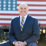 Photo of Tom Clark with American Flag in the background