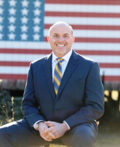 Photo of Tom Clark with American Flag in the background